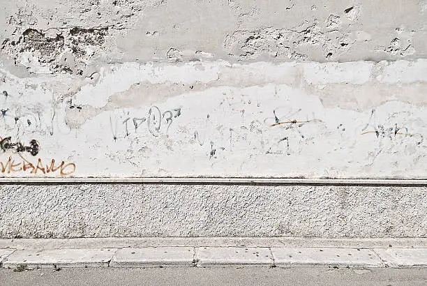 Photo of Old concrete grunge wall with sidewalk
