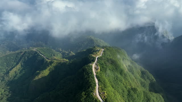 IndoDroneAerial view of the road on the hillside, the highest point of the mountain is beautiful among the mountains that are completely forested, Gunung Kelud and blue crater, Volcano Kelud, Kediri, East Java, Indonesia