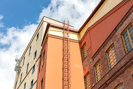 old building with renovated facade in orange color in the old town on blue sky background.