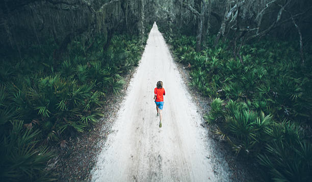istock Solitary male runs under trees on road at sunset 167313025
