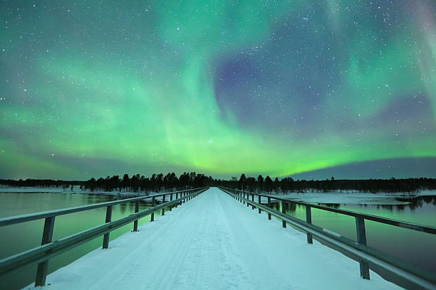 aurora borealis über eine brücke im winter, finnisch-lappland - aurora borealis aurora polaris lapland finland stock-fotos und bilder