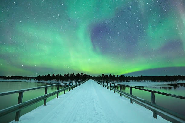 aurore boréale sur un pont en hiver, laponie finlandaise - aurora borealis aurora polaris lapland finland photos et images de collection