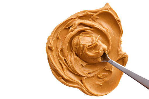 Peanut butter with spoon on white. Healthy food concept.