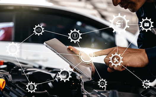 Mechanic using tablet checking up on car engines parts for fixing and repair, Smart service diagnostics software concept.