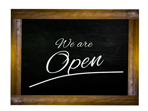 We're Open text on a blackboard with wooden frame, design for cafe door message.
