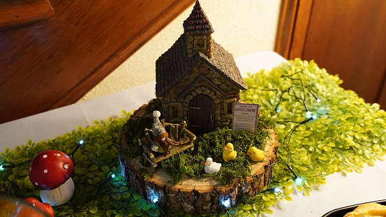 A closeup of a house miniature with lights as a decoration for baby shower