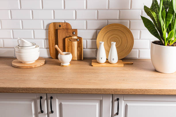 istock Beautiful kitchen background with different items and kitchen utensils made of eco-friendly materials. wooden countertop, white brick wall. 1673221033