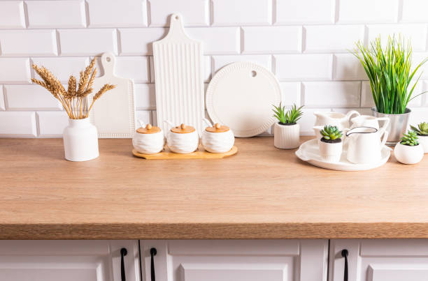 istock White kitchen utensils, cutting ceramic boards and dishes, a vase with ears of corn in the interior of a modern kitchen in white tones. 1673221053