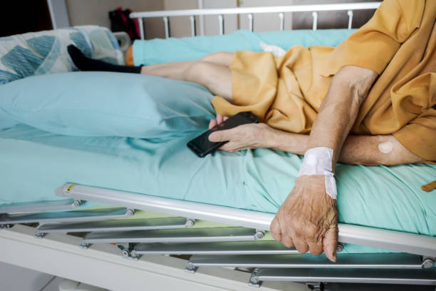 病院で寝たきりをする呼吸器疾患の病気のアジア人女性高齢患者 - senior women electronics people remote control ストックフォトと画像