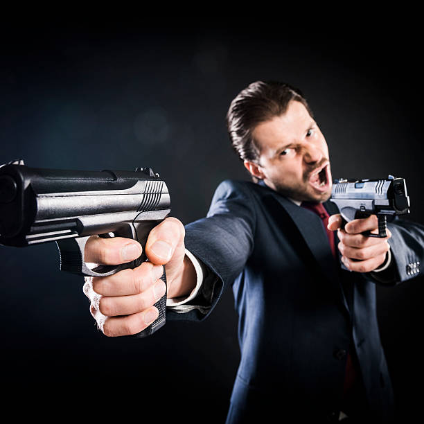 istock Crazy assassin, suit aiming with two guns, killer, mafioso, gangster 167330598