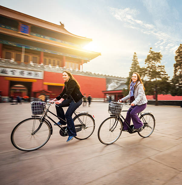 Friends riding retro bicycles along forbidden city