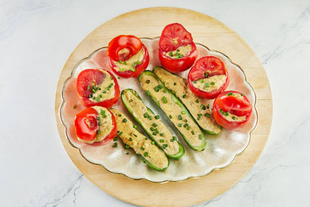 Stuffed tomatoes and cucumbers with green onions on plate.