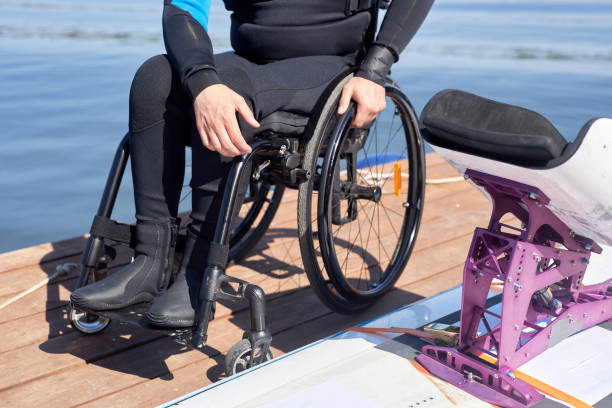 Wheelchair on the shore of wild Caribbean beach, turquoise waters and tropical blue sky. French Antilles. Fun and reduced mobility concept.