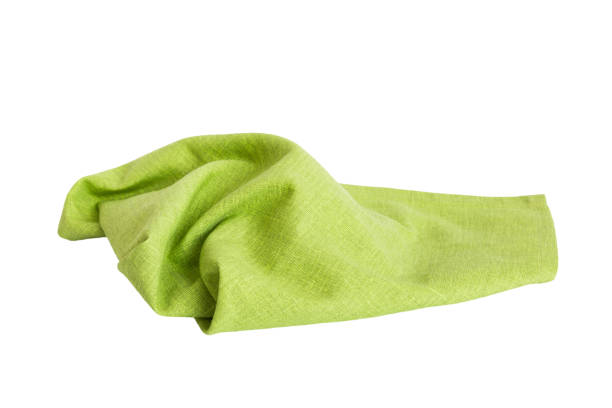 istock Green textile napkin isolated on white background. Folded decorative kitchen cotton towel. Top view 1673353009