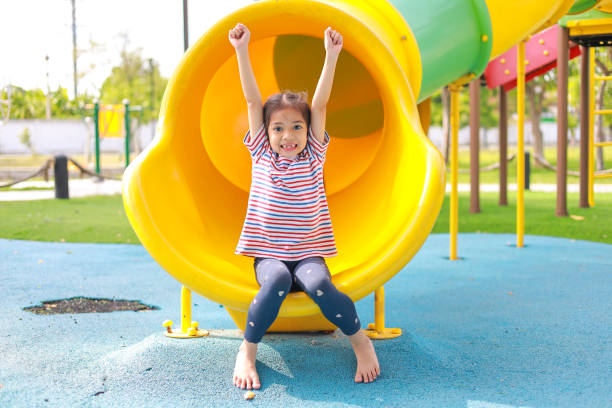 istock Little kid girl asian  while enjoying on the playground.Which increases the development and enhances outside the classroom learning skills concept. 1673354581