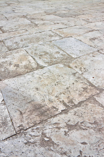 istock Old white limestone paving made with stone blocks of rectangular shape in a pedestrian zone 1673359426
