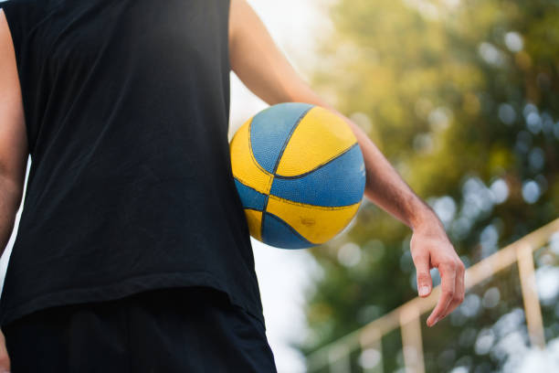 istock Close up to basketball under man's arm 1673398225