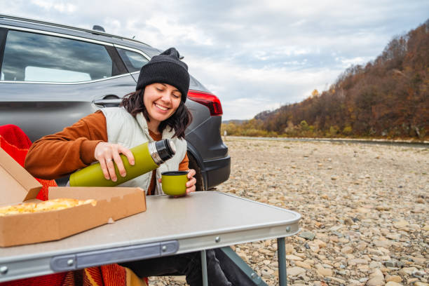 istock happy woman drinking warm tea road trip concept 1673446998