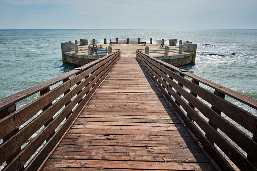 Wooden pier over the sea, at the bottom the horizon over the ocean