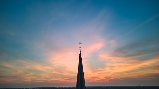 The silhouette of the cross and church bell tower in sunrise, sunset time. High quality photo