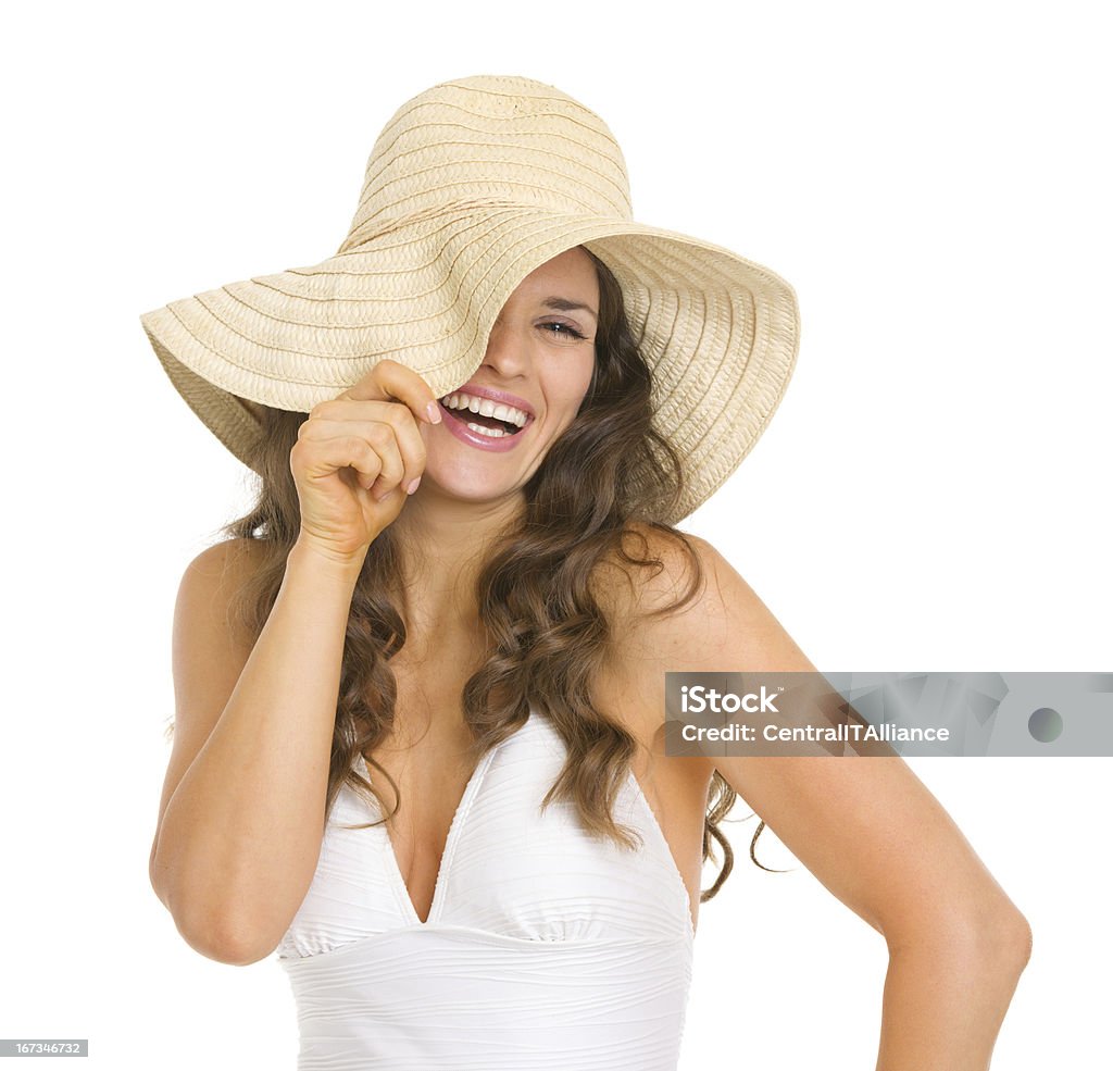 Улыбка молодая женщина в купальнике, играя с шляпа - Стоковые фото Белый фон роялти-фри
