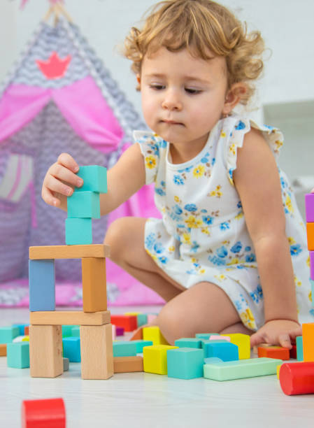 istock The child plays in the children's room with a wooden constructor. Selective focus. 1673508445