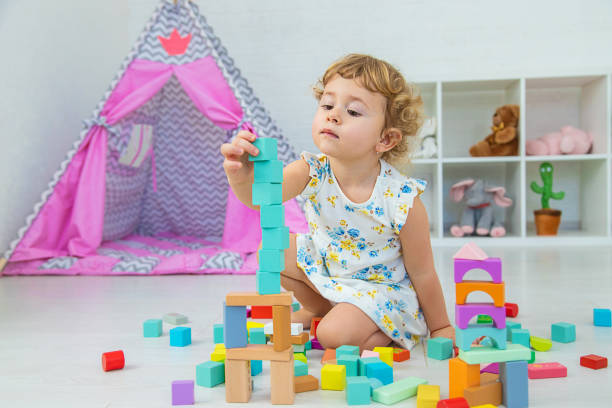 istock The child plays in the children's room with a wooden constructor. Selective focus. 1673508459