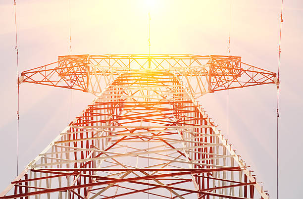 Electricity pylon against sunny sky stock photo