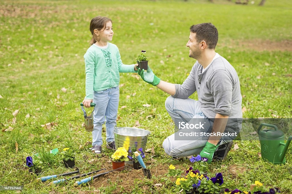 Father and daughter in the garden Father giving  flowers to his daughter, ready to plant. 30-39 Years Stock Photo