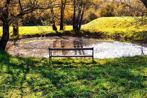View of a wooden bench in the Karst pond V Lasatkah, Slovenia