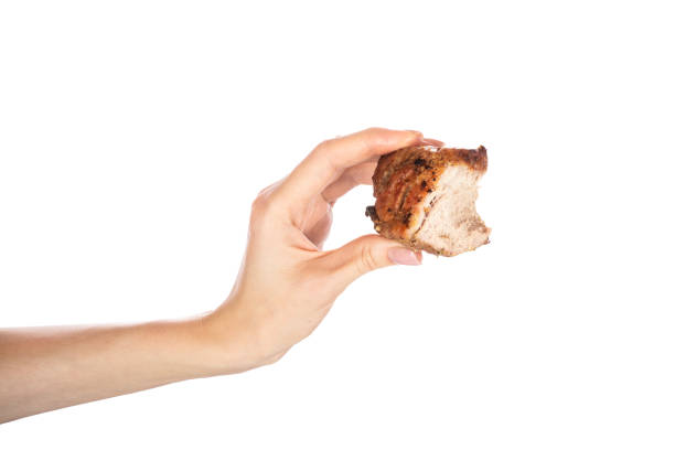 istock Grilled meat in female hand isolated on white background. 1673530787