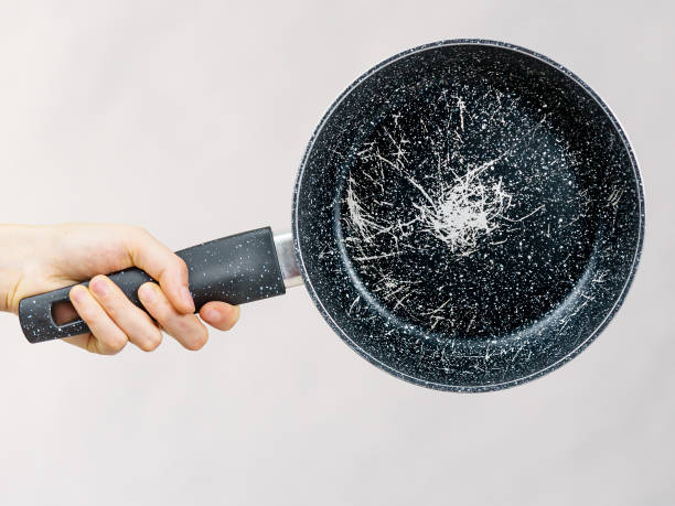 istock Hand holding scratched frying pan 1673533432