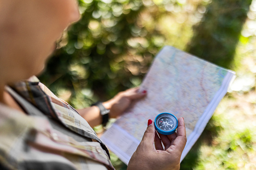 Hiking Woman Traveler With Backpack Checks Map to Find Directions