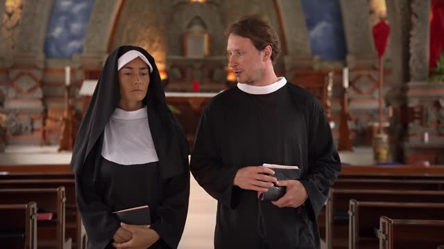 Man and Woman Talking in Church about Religion and Faith. Nun and Priest Walk Inside Church before Prayer. Young Adult Pope and Sister Talk about God Together Indoor Chapel. Talk about Bible and Jesus