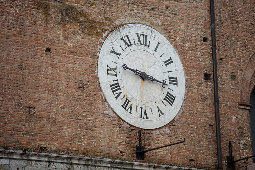 Sepia toned image of an old clock face isolated on a white background