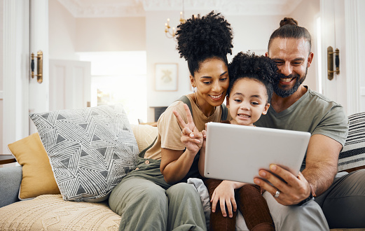 Happy, family and parents with a tablet, boy and connection with games, cartoon and streaming movies. Home, mother or father on a couch, child or kid with technology, relax or social media for fun