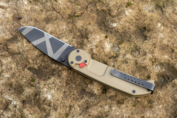 istock Tactical folding knife on the stone background 1673595479