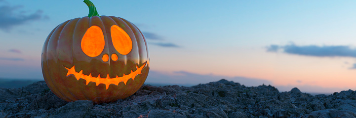 Illuminated carved pumpkin on a rocky surface at sunset 3d render