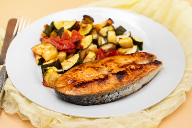 istock Fried salmon with vegetables on white plate 1673613328