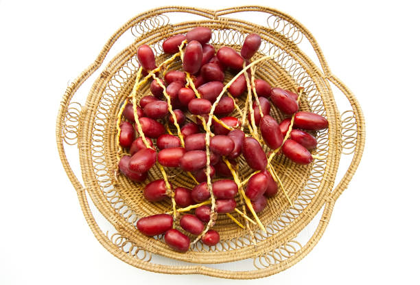 Red date palm fruit in basket isolated on white background, healthy eating