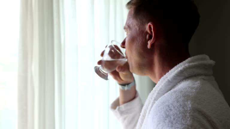 Man wakes up in morning and drinks glass of water