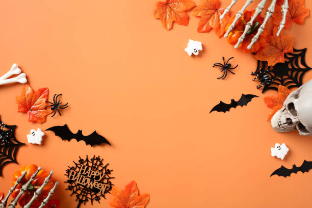 istock Halloween background with pumpkins, skeleton hands, bats, bones, spiders, skull on pastel orange table. Top view, flat lay. 1673664362