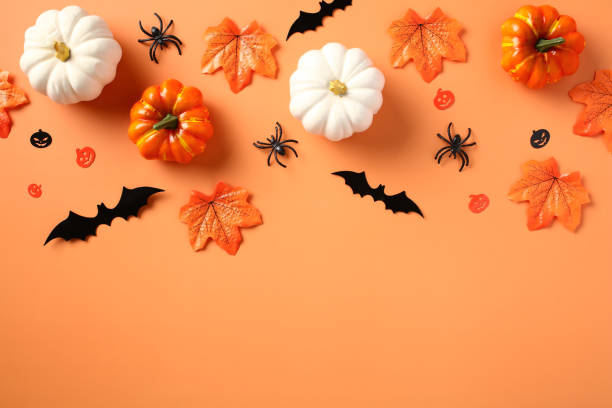 istock Halloween flat lay composition with pumpkins, spiders, bats, maple leaves on pastel orange background. 1673666360