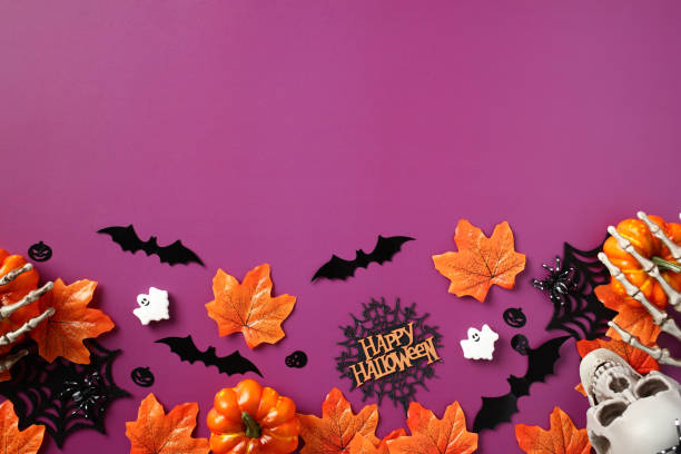 istock Halloween background. Flat lay Halloween decorations, skull, pumpkins, orange maple leaves, bats, ghosts on purple table. Halloween party invitation template, poster design. 1673672375