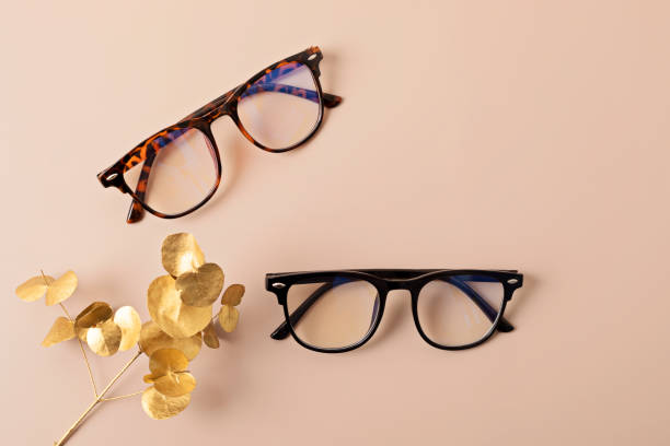 istock Stylish eyeglasses over pastel background. Optical store, glasses selection, eye test, vision examination at optician, fashion accessories concept. Top view, flat lay 1673714371