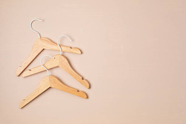 istock Wooden hangers on beige background. Responsible shopping 1673714375