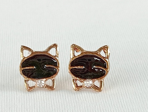 One pair of black cat earrings on a white background.