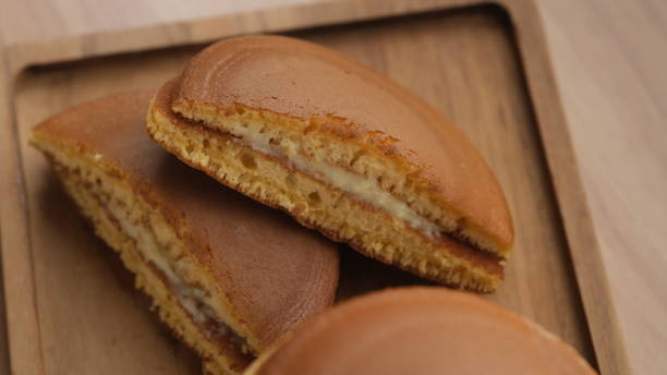 Dorayaki is a type of Japanese confection. Dorayaki is a type of Japanese confection. It consists of two small pancake-like patties made from castella wrapped around a filling of sweet azuki bean paste. red bean dessert stock pictures, royalty-free photos & images