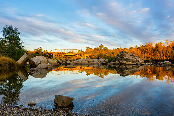 Rainbow bridge and clouds reflecting in the water Rainbow Bridge in Folsom California at sunset sacramento stock pictures, royalty-free photos & images