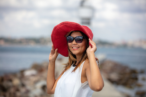 Portrait of young asian lady with pink hat in front of Istanbul cityscape.